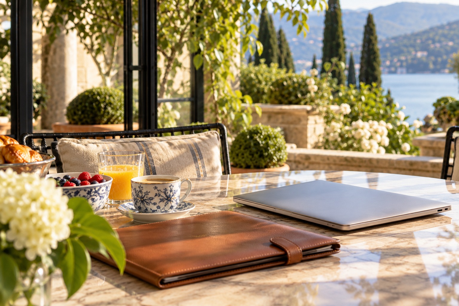 A portfolio folder and closed laptop on the woman’s garden-room table